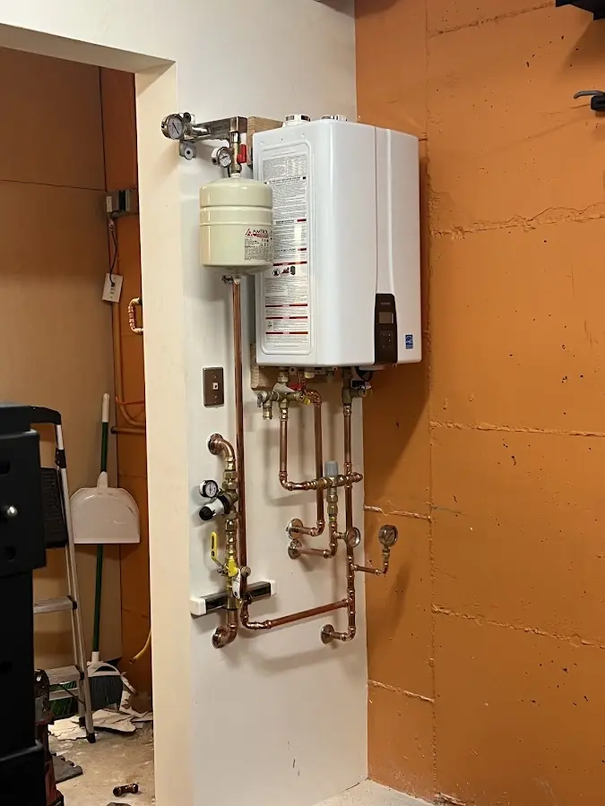 Plumbing technician inspecting water heater connections in Benton Park